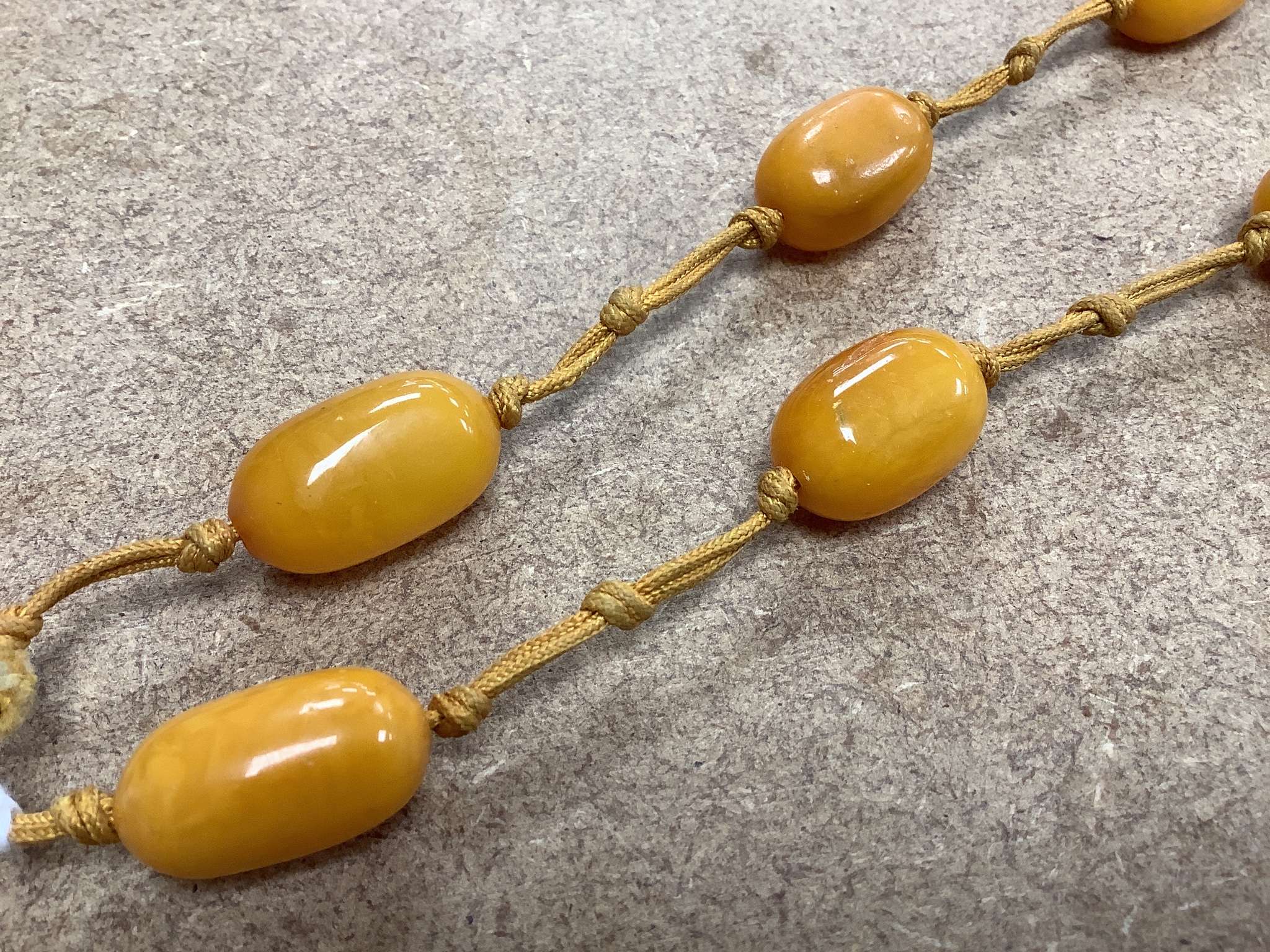 A single strand oval amber bead pendant necklace, 92cm, gross weight 60 grams.